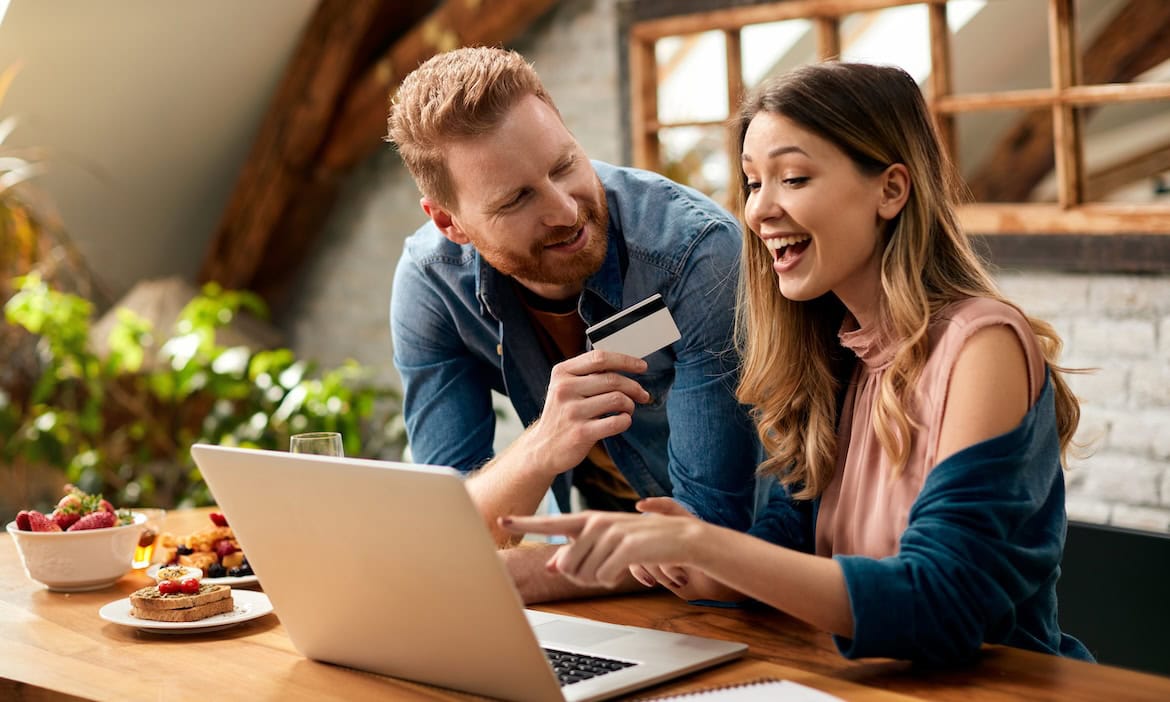 Frau und Mann lösen eine Cashback-Prämie online ein: Cashbacks sind die beliebtesten Prämien von deutschen Versicherungskunden.