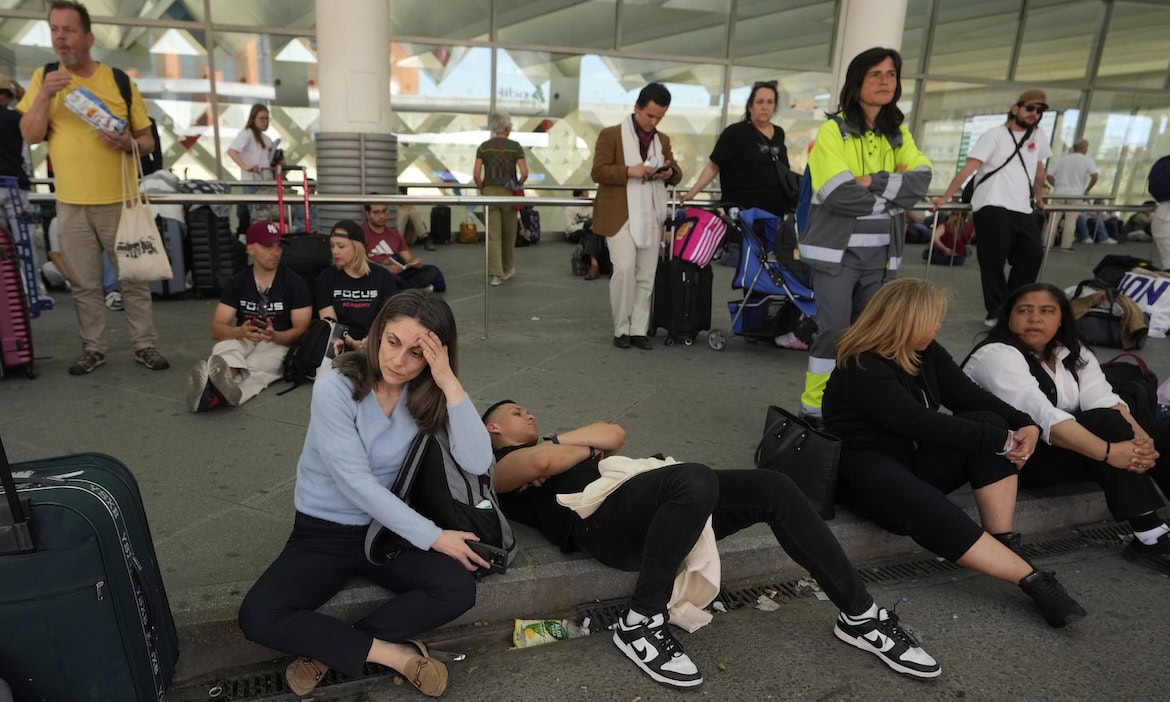 Fahrgäste warten vor dem Bahnhof Atocha während eines landesweiten Stromausfalls in Madrid am 28. April: Durch den Stromausfall in Spanien und Portugal könnten Milliardenkosten auf die Versicherer zukommen.