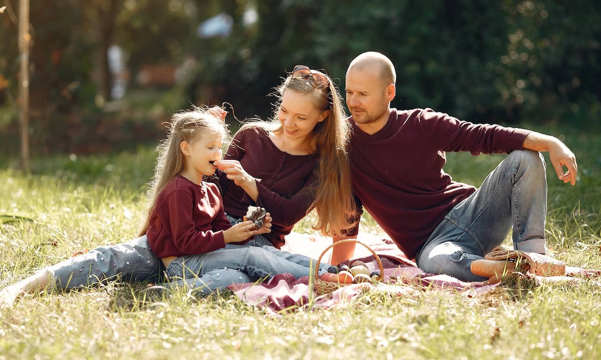 Familie picknickt im Park: Eltern spekulierenn häufiger mit Geld als die Gesamtbevölkerung.