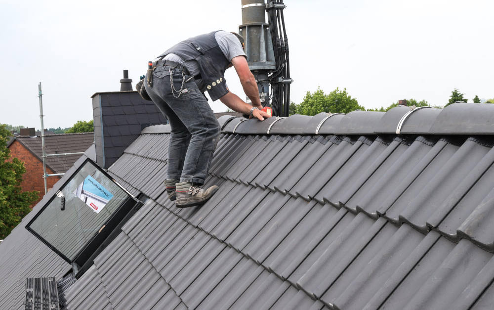 Ungesicherter Dachdecker bei der Arbeit (Symbolbild): Preise für Berufsunfähigkeitsversicherung insgesamt sehr stabil