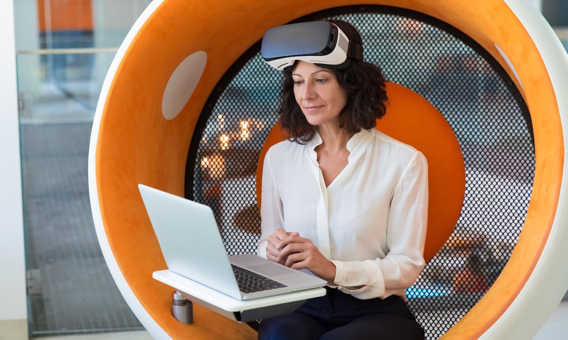 Mitarbeiterin arbeitet mit KI im Büro: KI-Agents und Spatial Intelligence gehören zu den wichtigsten Tech-Trends in der Versicherungsbranche.