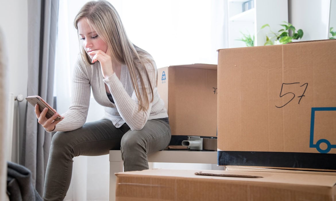 Junge Frau organisiert ihren Umzug: Der Auszug aus dem Elternhaus ist ein guter Anlass, um Neukunden oder Cross-Selling-Kunden zu akquirieren.