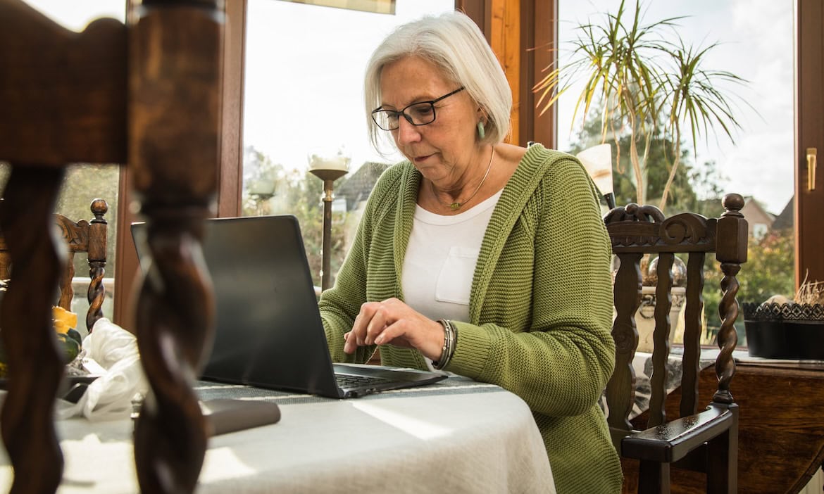 Rentnerin arbeitet am Laptop: Das IW Köln hat errechnet, wieviel es kosten würde, wenn der Staat Rentnern die Aktivrente bis zu 2.000 Euro steuerfrei anbieten würde.